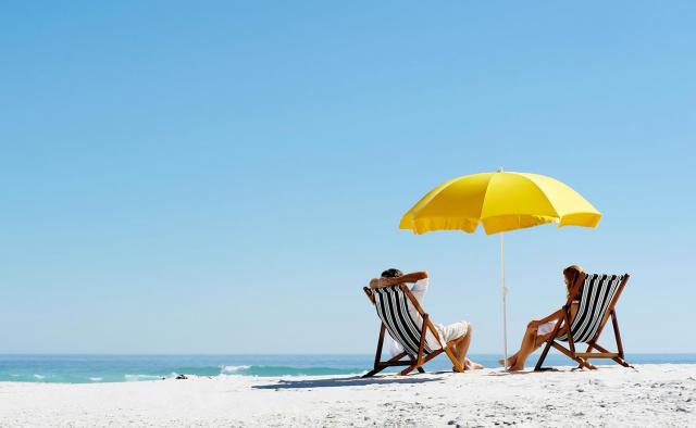 Deux personnes sur la plage sous un parasol